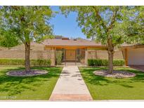 Charming single-story home with a brick wall and beautifully manicured landscaping at 5112 N 32Nd Pl, Phoenix, AZ 85018