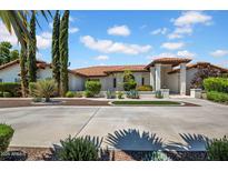 Stunning home featuring a beautifully landscaped front yard with circular driveway and desert landscaping at 5320 W Soft Wind Dr, Glendale, AZ 85310