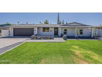 Charming single-story home with manicured lawn and stylish gray brick accents at 727 N Beverly --, Mesa, AZ 85201