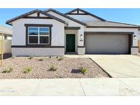 Charming single-story home featuring a desert landscape and a lovely green front door at 8437 W Clemente Way, Florence, AZ 85132