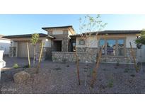 Charming single-story home featuring a stone facade, well-manicured yard, and a two-car garage at 12324 W Parkway Ln, Avondale, AZ 85323