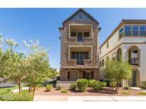 Beautiful stone clad three-story home with balconies and front yard landscaping at 1713 E Bridgeport Pkwy, Gilbert, AZ 85295