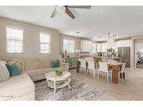 Open concept living room with a large sectional couch, dining table, and white kitchen at 1713 E Bridgeport Pkwy, Gilbert, AZ 85295