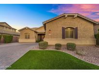 Charming single-story home boasts a landscaped front yard and inviting facade under a vibrant evening sky at 20269 E Hummingbird Dr, Queen Creek, AZ 85142