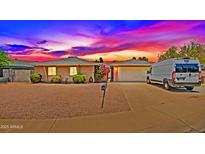 Charming single-story home featuring a brick exterior, desert landscaping, and a two-car garage during a lovely sunset at 3450 W Kaler Dr, Phoenix, AZ 85051
