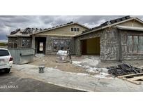 Exterior view of a home under construction featuring a gray exterior, open garage and tile roof at 6446 E Omega Cir, Mesa, AZ 85215