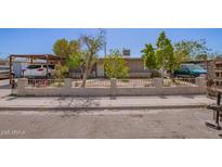 Charming single-story home featuring a fence, mature trees, and covered parking, offering a blend of comfort and convenience at 705 S Pima --, Mesa, AZ 85210