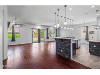 Open-concept living room features wood floors, abundant natural light and a stylish kitchen island at 7911 E Posada Ave, Mesa, AZ 85212
