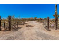Wide angle shot of the property entrance with desert landscaping and open gate at 10480 W Martin Rd, Casa Grande, AZ 85194