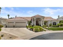 Stunning single-story home with a tile roof, lush landscaping, and a three-car garage on a sunny day at 11439 E Bella Vista St, Scottsdale, AZ 85259