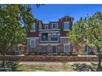 Charming multi-story townhouse featuring stone accents, multiple windows, and mature landscaping at 134 W Campbell Ct, Gilbert, AZ 85233