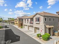 Street-level view of modern townhomes with attached garages and well-kept landscaping at 1441 N 80Th Ln, Phoenix, AZ 85043