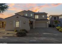 Two-story home with a two-car garage and a well-maintained front yard and neutral color palette during a scenic sunset at 15046 W Post Dr, Surprise, AZ 85374