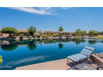 Picturesque backyard view with waterfront, lounge chairs, and lovely home exteriors on a sunny day at 20119 N Laguna Way, Maricopa, AZ 85138