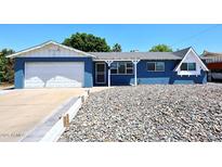Charming blue single-story home with white trim, a stone yard, and a well-maintained front yard at 3202 W Joan De Arc W Ave, Phoenix, AZ 85029