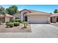 Charming single-story home with a well-manicured front yard, desert landscaping, and a two-car garage at 625 W Douglas Ave, Gilbert, AZ 85233