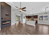 Inviting living room featuring a modern fireplace, ceiling fan, and an open view to the kitchen at 1332 W Blue Ridge Ct, Chandler, AZ 85248