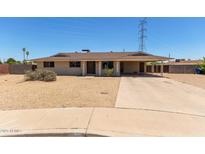 Single story home featuring a large covered carport and desert landscaping at 1351 E Ellis Cir, Mesa, AZ 85203