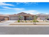 Charming single-story home featuring a well-maintained front yard with desert landscaping and a two-car garage at 17051 W West Wind Dr, Surprise, AZ 85387