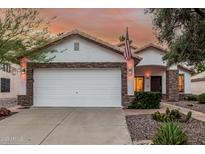 Charming home featuring stone accents, white stucco and a two-car garage, and desert landscaping at 2108 E Patrick Ln, Phoenix, AZ 85024