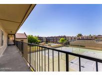 Expansive balcony view of the community pool, tennis courts, and well-maintained landscaping at 461 W Holmes Ave # 323, Mesa, AZ 85210