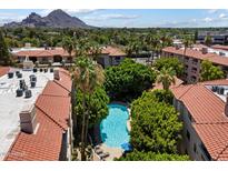 Aerial view of a community pool with palm trees and red tiled roofs at 5104 N 32Nd St # 114, Phoenix, AZ 85018