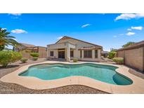 Inviting backyard oasis features a sparkling pool and covered patio, perfect for outdoor entertaining at 10046 E Posada Ave, Mesa, AZ 85212