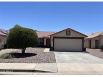 Charming single-story home with a well-maintained front yard and a two-car garage at 15731 W Evans Dr, Surprise, AZ 85379