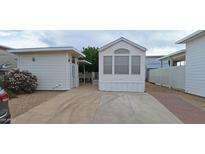 Charming manufactured home features a well-maintained front yard, covered parking, and beautiful landscaping at 17200 W Bell Rd # 1501, Surprise, AZ 85374