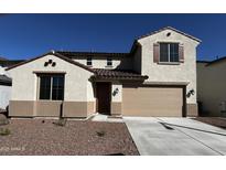 Two-story home featuring a two-car garage, stucco siding, and a tile roof, under a bright blue sky at 17535 W Fulton St, Goodyear, AZ 85338