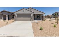 Charming single-story home featuring neutral stucco, a two-car garage, and desert landscaping on a sunny day at 18340 W Patrick Ln, Surprise, AZ 85387