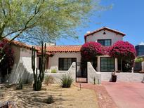 Charming home featuring a red tile roof, stucco walls, desert landscaping, and vibrant bougainvillea bushes at 56 W Windsor Ave, Phoenix, AZ 85003