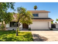 Charming two-story home boasts a well-maintained lawn, mature trees, and a two-car garage at 1353 W Kiowa Ave, Mesa, AZ 85202