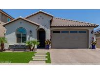Charming single-story home featuring a tile roof, arched window, desert landscaping and a brick driveway at 15276 W Latham St, Goodyear, AZ 85338
