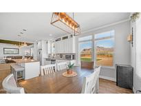 Bright dining room features a wooden table with white chairs, modern light fixture, and stunning mountain views at 2242 E 12Th Ave, Apache Junction, AZ 85119