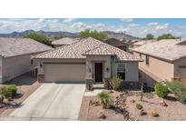 Charming single-story home featuring desert landscaping, a two-car garage, and a welcoming entryway at 22574 W Moonlight Path, Buckeye, AZ 85326