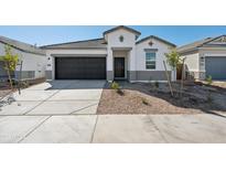 Charming single-story home with a modern facade, dark garage door, and well-maintained landscaping at 25471 W Fraktur Rd, Buckeye, AZ 85326