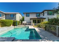 Backyard pool with travertine patio and wrought iron fence surrounding two-story home at 4167 E Sierra Madre Ave, Gilbert, AZ 85296