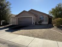 Charming single-story home featuring a two-car garage and desert landscaping at 45499 W Sky Ln, Maricopa, AZ 85139