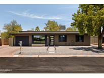 Charming single-story home features a brick exterior, desert landscaping, and a modern front door at 7620 N 12Th Pl, Phoenix, AZ 85020