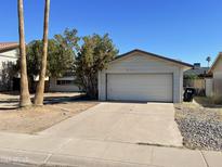 Attached one-car garage with a concrete driveway and desert landscaping in the front yard at 8114 E Jackrabbit Rd, Scottsdale, AZ 85250