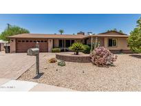 Charming single-story home with a well-maintained xeriscaped front yard and brick accents at 8620 E Sells Dr, Scottsdale, AZ 85251
