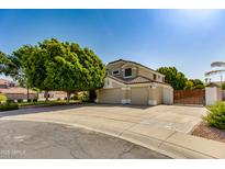 Charming home featuring a spacious three car garage and desert landscaping with a large shade tree in the front yard at 91 W Baylor Ln, Gilbert, AZ 85233