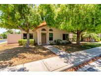 Charming single-story home featuring mature trees, neutral stucco, and a welcoming front entrance at 967 E Hearne Way, Gilbert, AZ 85234