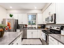 Modern kitchen with stainless steel appliances, gray countertops and white cabinetry at 2090 S Dorsey Ln # 1019, Tempe, AZ 85282