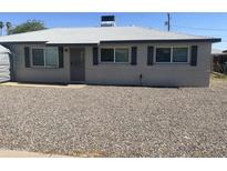 Charming single-story home with light grey exterior, black shutters, and xeriscaped front yard for low maintenance at 2431 W Seldon Ln, Phoenix, AZ 85021