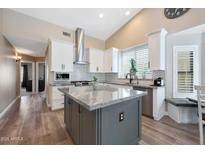 Bright kitchen boasts white cabinets, gray island, stainless steel appliances, and modern fixtures at 26647 N 43Rd N St, Cave Creek, AZ 85331