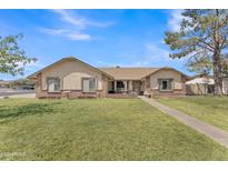 Charming single-story home with a well-manicured lawn and a classic brick facade at 3046 E Dover St, Mesa, AZ 85213