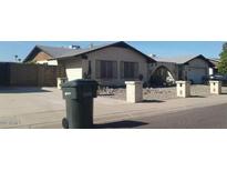 Charming single-story home with low maintenance desert landscaping and neutral exterior paint at 3935 W Muriel Dr, Glendale, AZ 85308