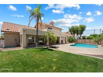 The home features a lush lawn and private pool, perfect for outdoor living and entertaining at 4002 N San Gabriel Cir, Mesa, AZ 85215